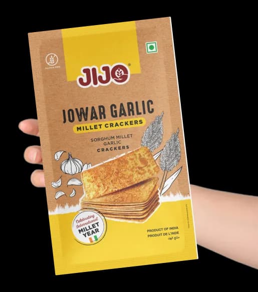A pack of JIJO Jowar Garlic millet crackers held in a hand